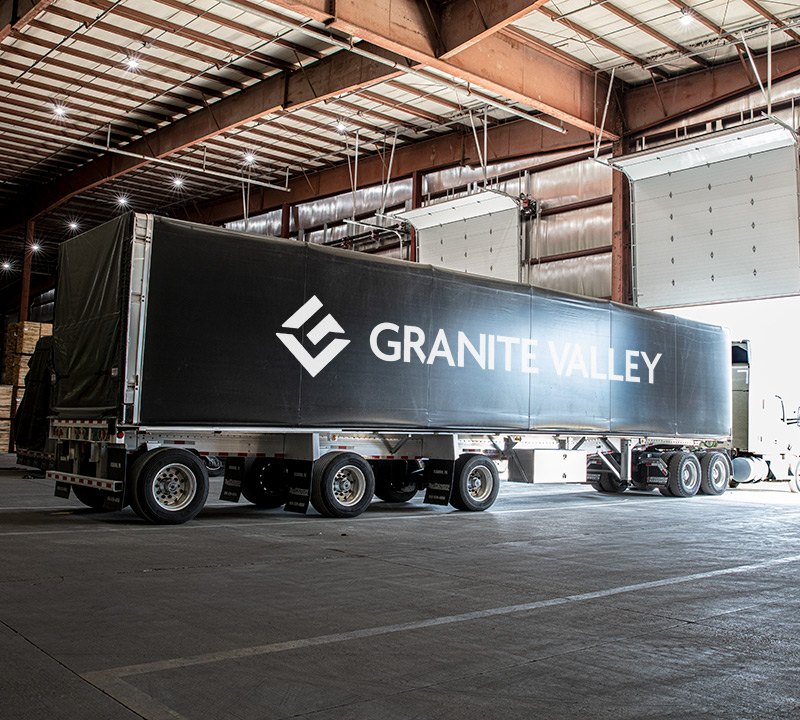 a semi trailer with a Granite Valley Forest Products logo parked inside of a Granite Valley Forest Products facility