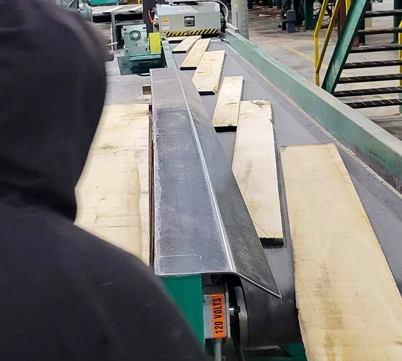 employee inspects boards on conveyor